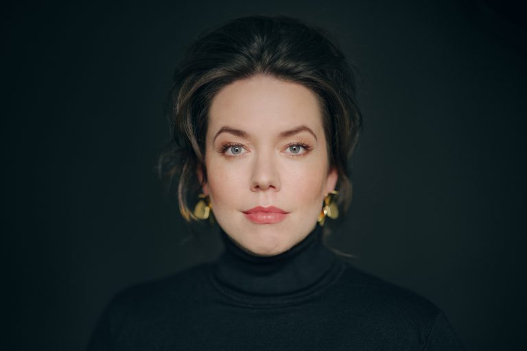 Magdalena Hinterdoblerin muotokuva. Hän katsoo suoraan kameraan, hänellä on tummat hiuset ja musta poolopaita. Tausta on musta.